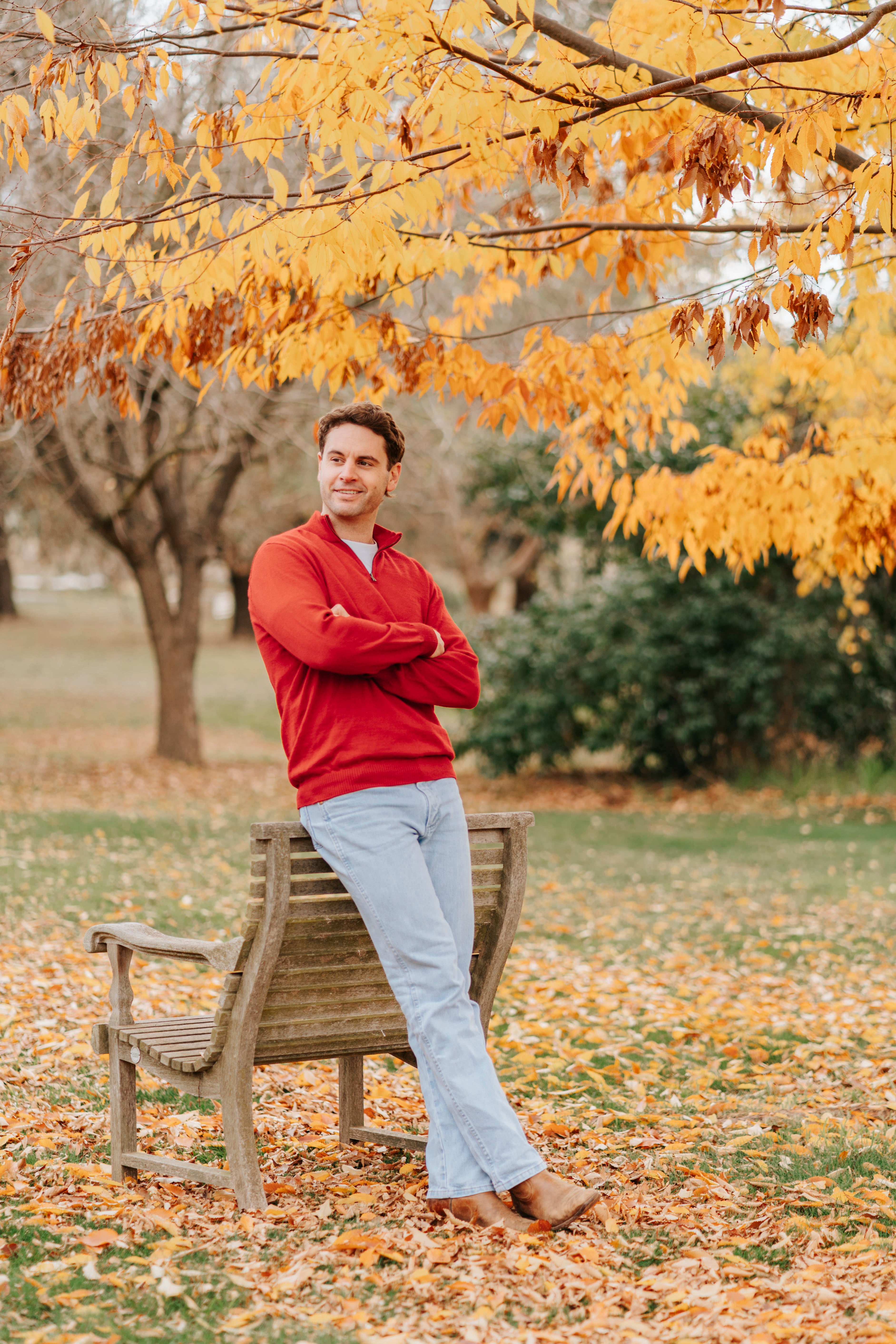 Man wearing a red Merino wool sweater and light blue jeans