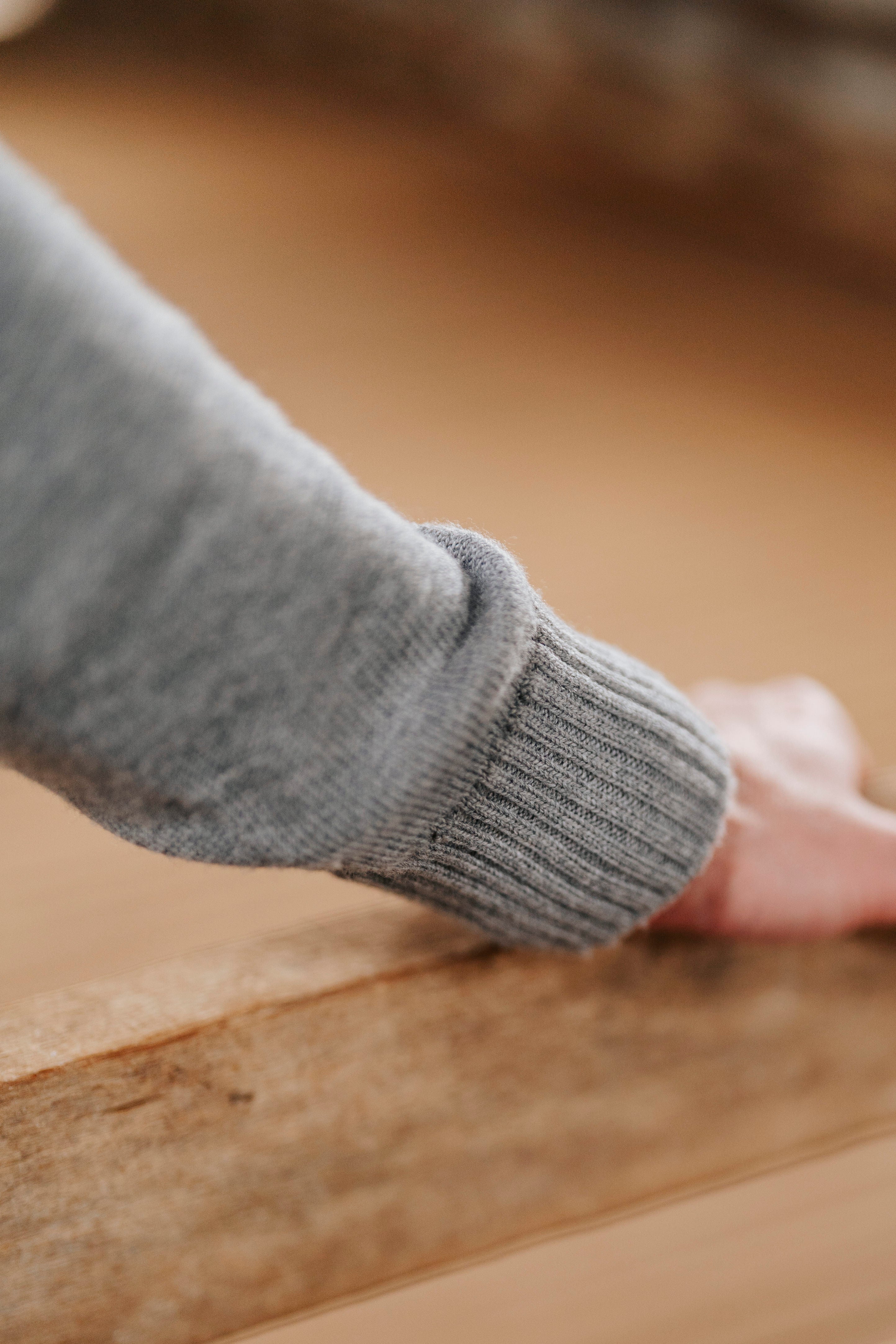 Gray sweater sleeve on a wooden surface