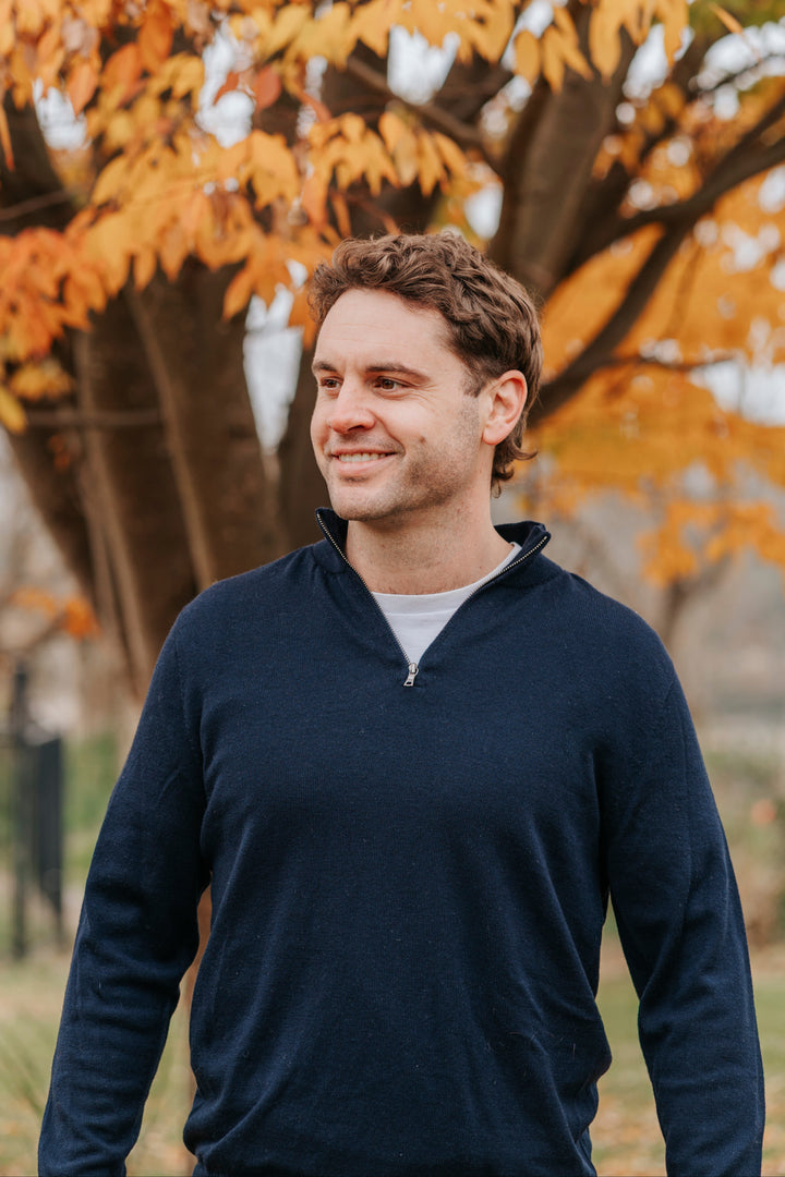 Man wearing a Navy Merino wool sweater and light blue jeans