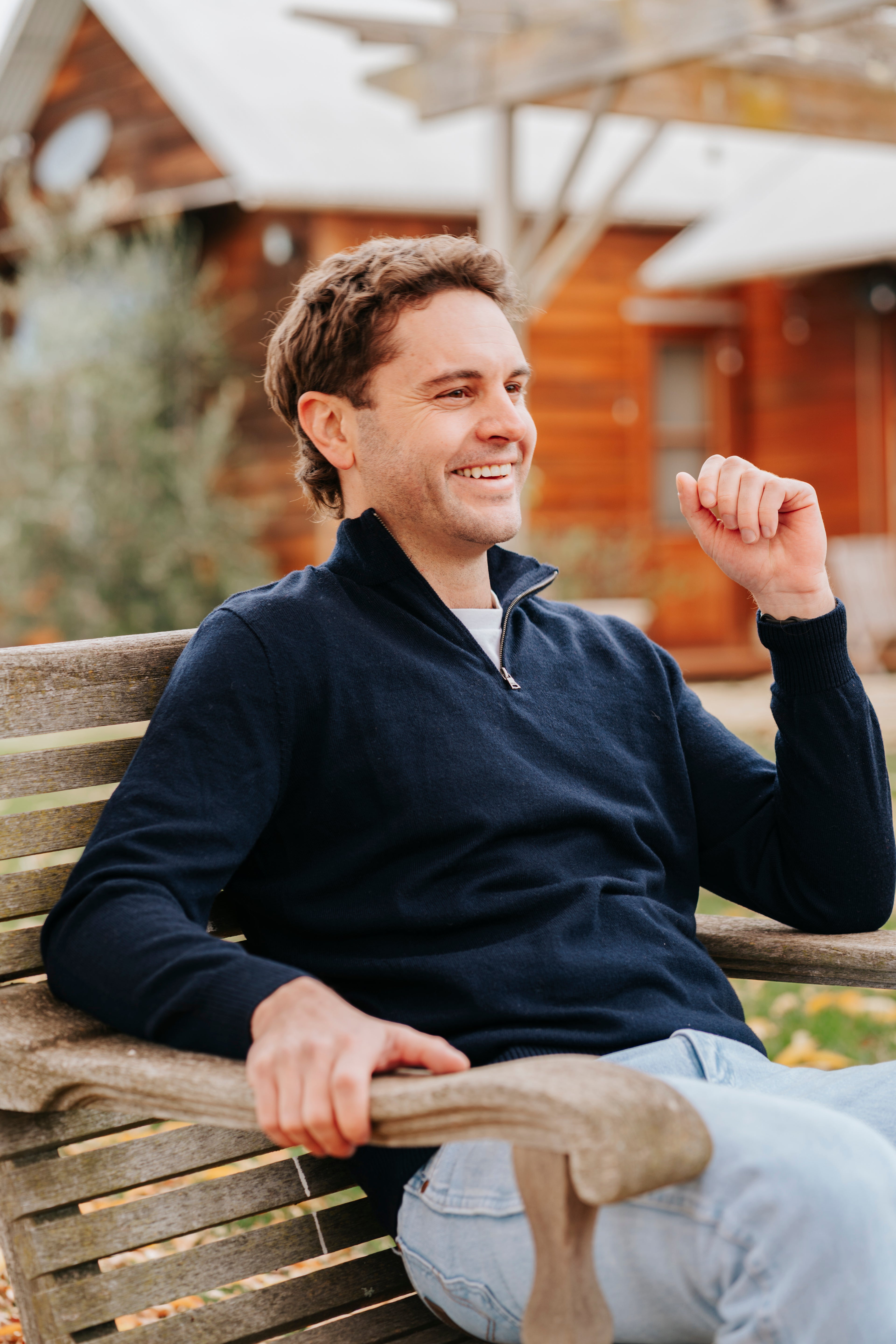 Man wearing a navy Merino wool sweater and light blue jeans
