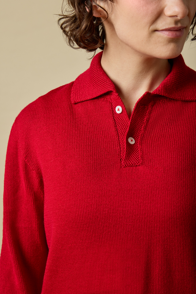 Red knitted Sir W. Merino polo shirt worn by a person against a beige background