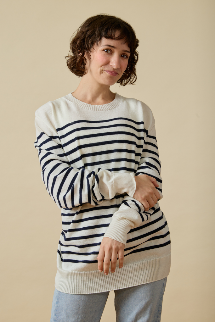Woman wearing a striped Sir W. Merino sweater against a beige background