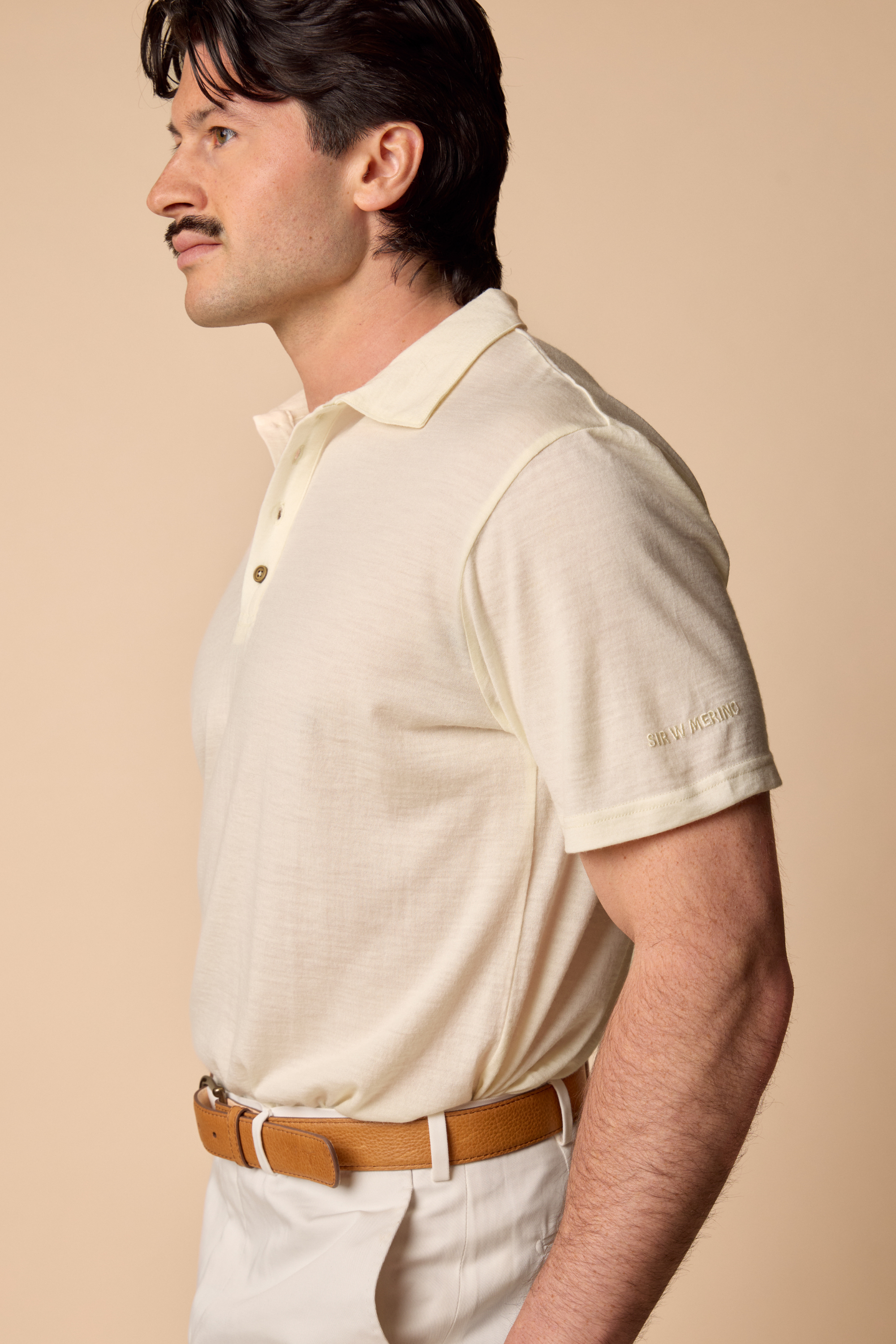 Man wearing a Sir W. Merino George polo in white, side view
