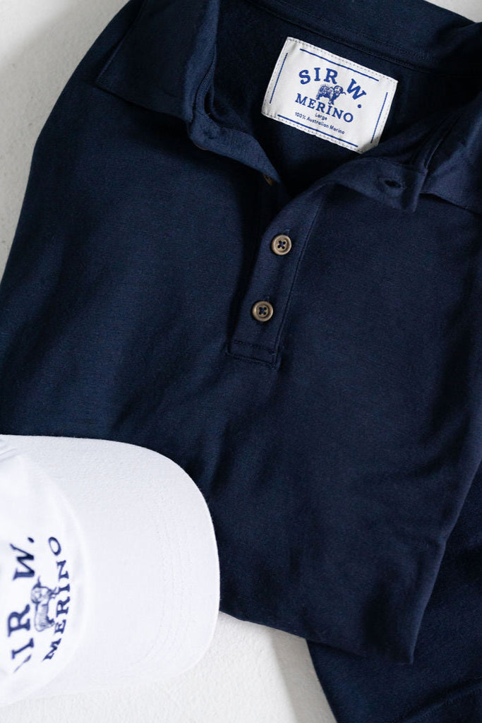 Merino wool polo top folded next to shorts and sneakers