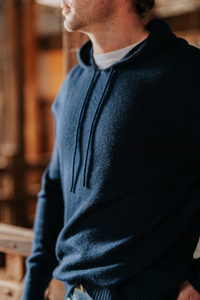Man wearing a Navy hoodie with a blurred background