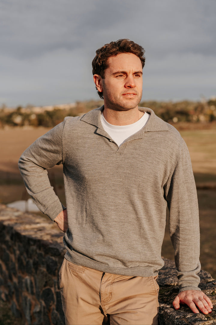 Man standing outdoors with a cloudy sky in the background