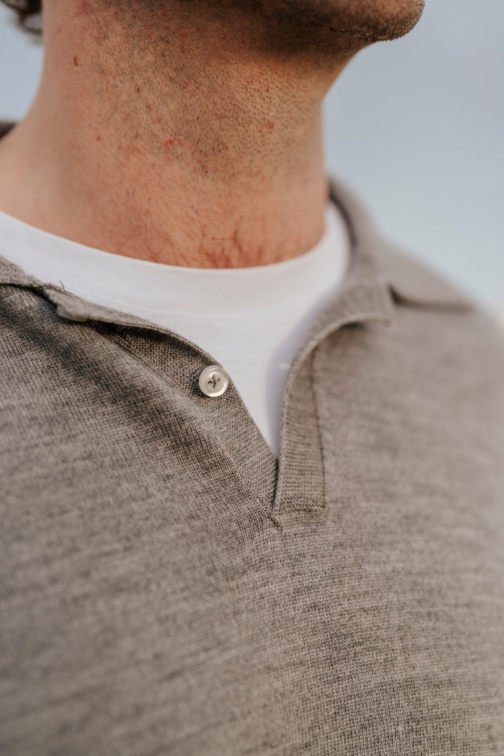 Close-up of a person wearing a brown polo shirt with a white collar.