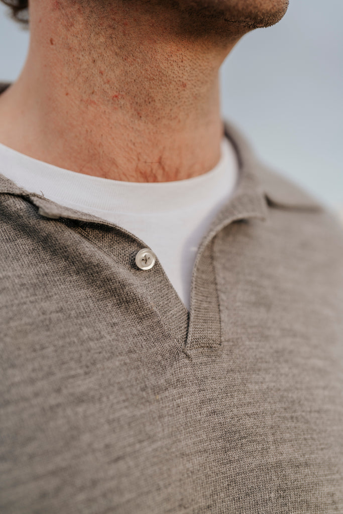 Close-up of a person wearing a brown polo shirt with a white collar.