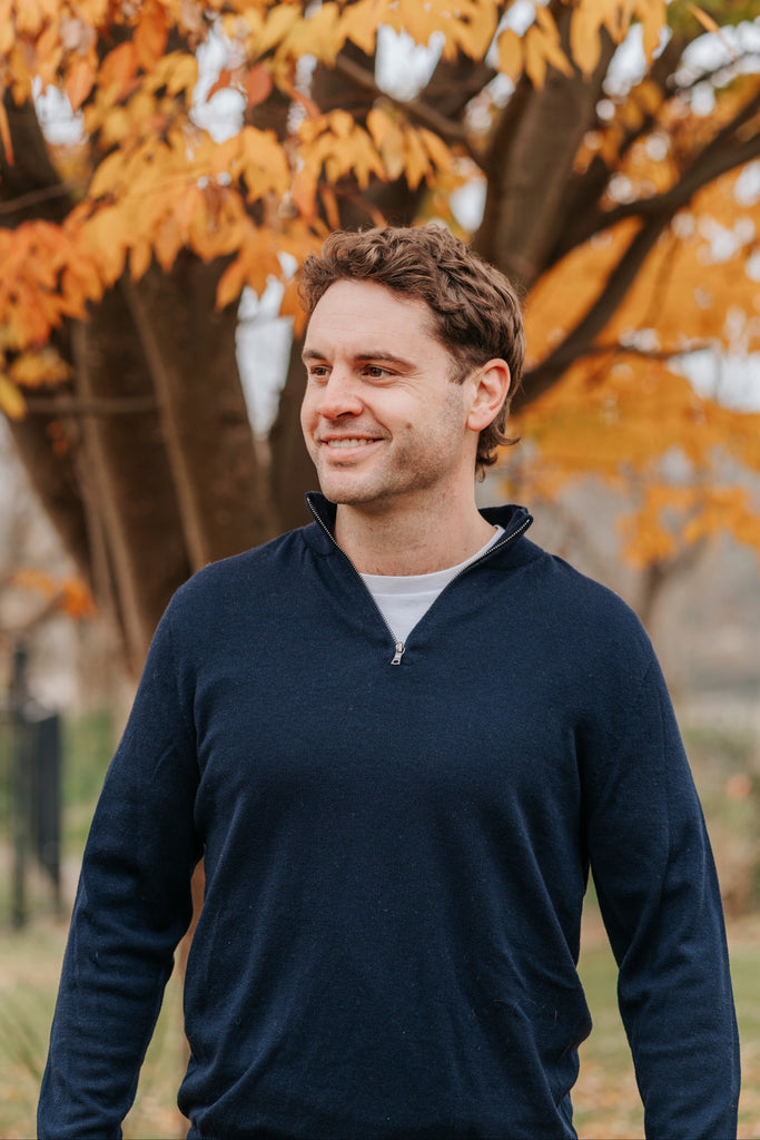 Man wearing a Navy Merino wool sweater and light blue jeans 