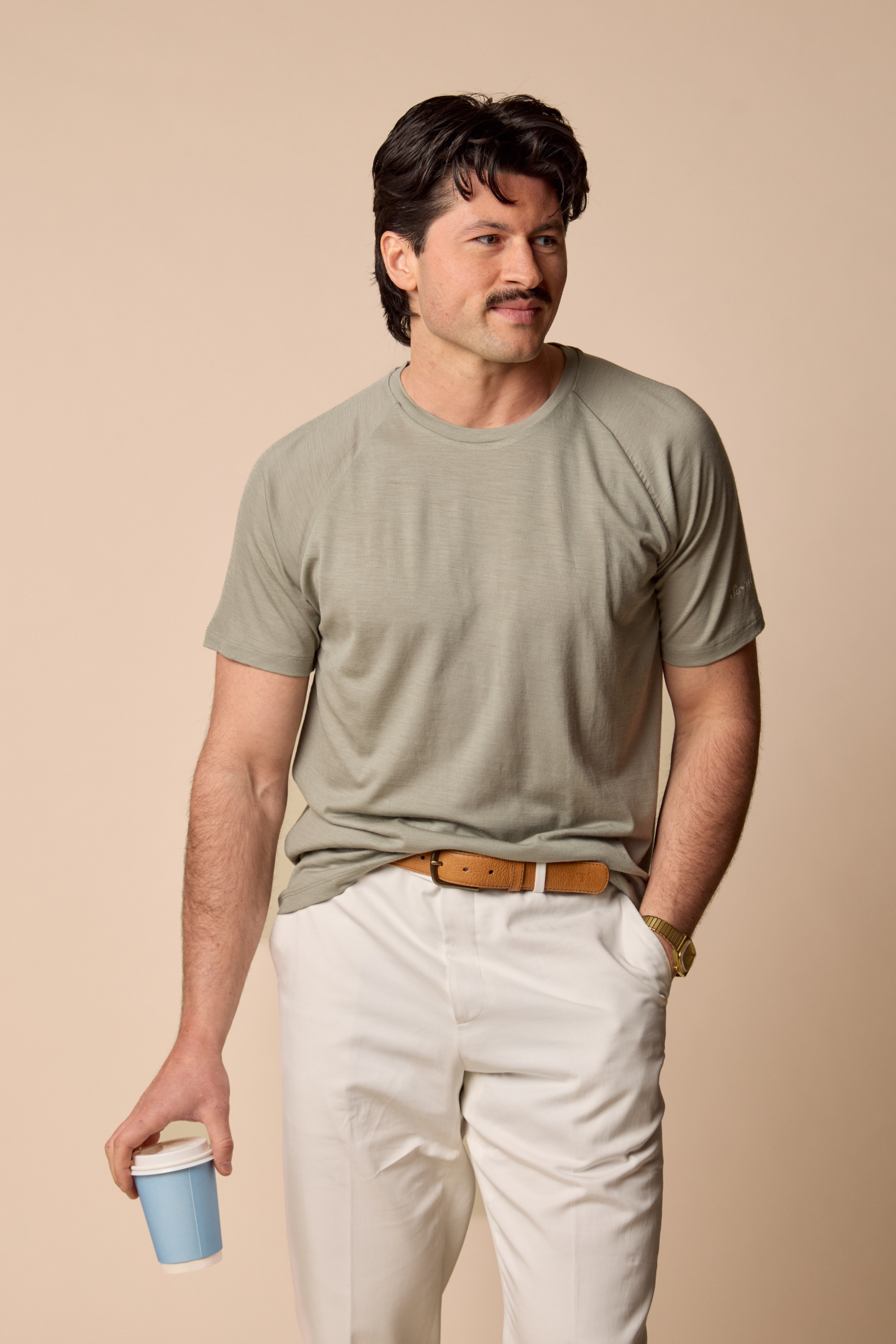 Sir W. Merino cassius shadow grey tee and white pants with coffee in hand.